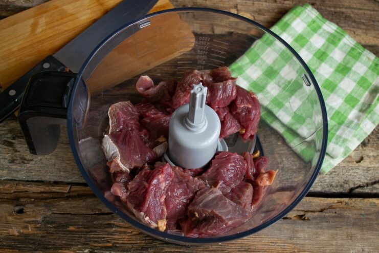 Grinding the Beef in a Blender Chunks of beef inside a blender bowl before grinding.