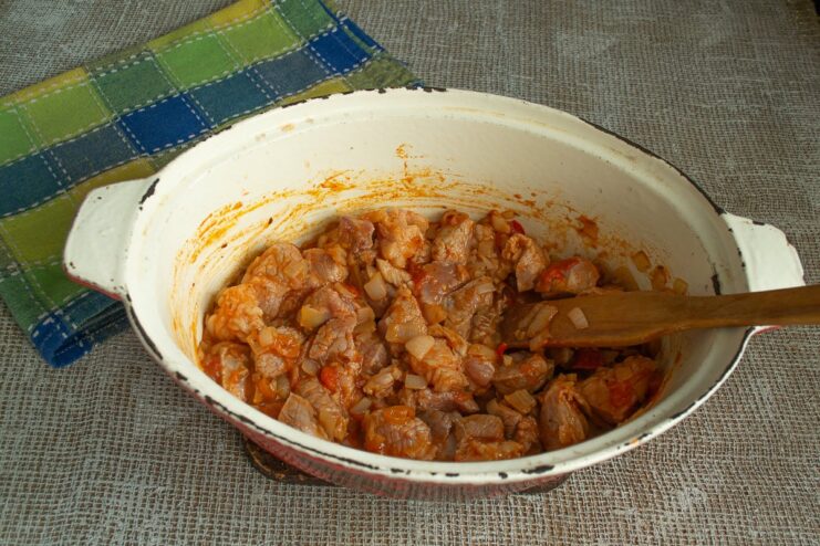 Seasoning the Meat and Preheating the Oven for Baking Seared pork in a pan being seasoned with turmeric and black pepper.