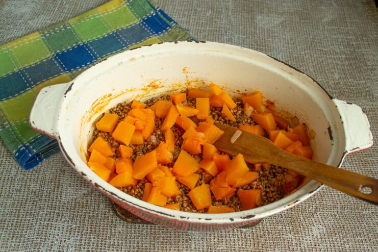 Adding Sweetness and Color with Butternut Squash Cubes of butternut squash layered on top of the buckwheat in the roasting pan.