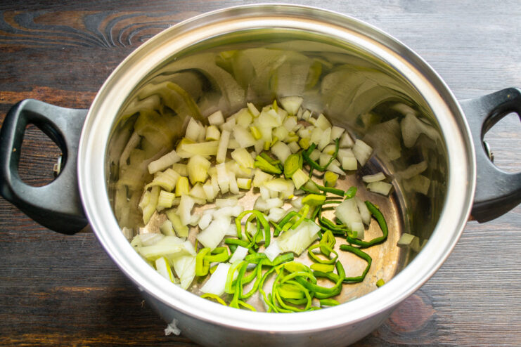 Starting the Soup Base with Chopped Onions Chopped onions being added to a thick-bottomed pot to start the soup.
