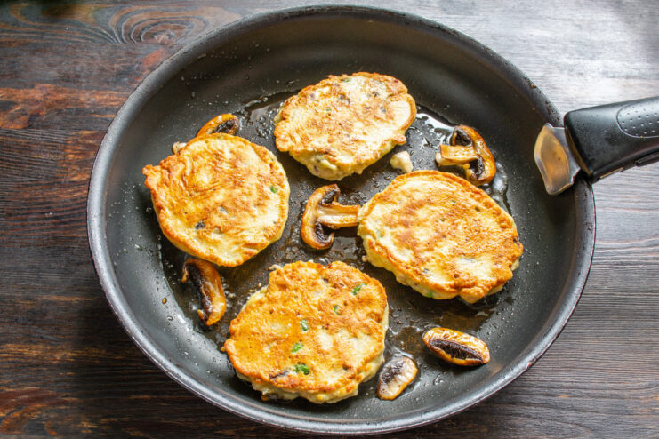 Cooking Fritters Until Golden Brown Mushroom fritters frying in a pan, cooked to a perfect golden-brown on one side.