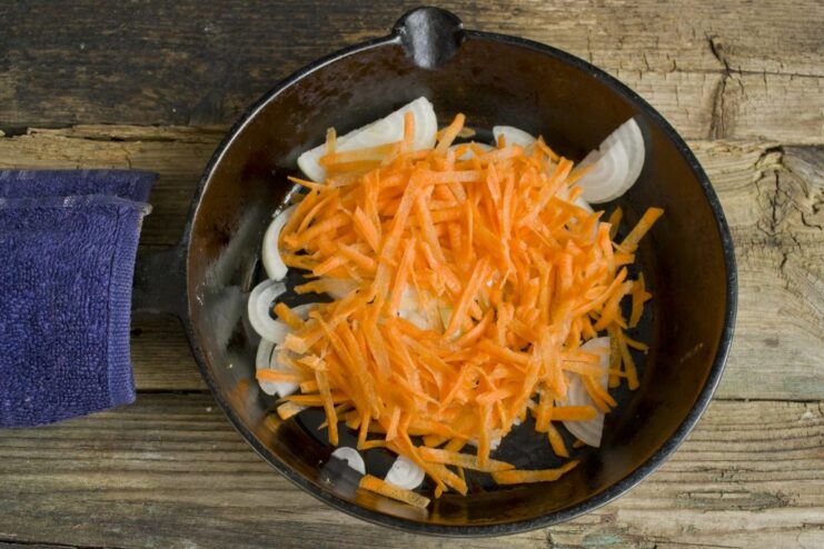 Building Flavor: Sautéing Onions and Carrots Sautéing chopped onions and grated carrots in a skillet until soft and fragrant.
