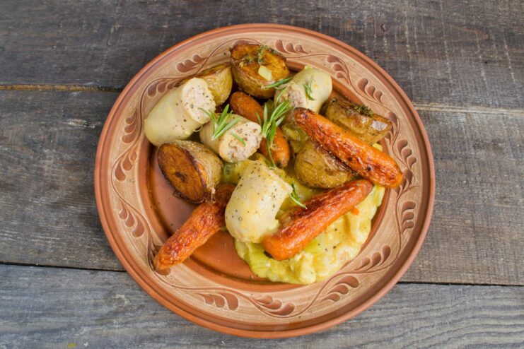 The finished dish: chicken goulash served hot with roasted vegetables and sausage A final plated dish of chicken goulash with roasted vegetables and sausage, ready to be served.