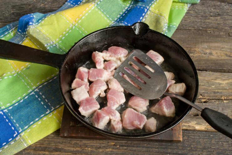 Searing Pork Cubes for Maximum Flavor Cubes of pork being seared in a hot skillet until golden brown.