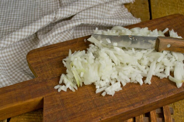 Sautéing Onions for the Vegetable Base Finely chopped onions being sautéed in a skillet until translucent.