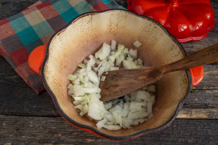 Sautéing chopped onions for the vegetable sauce base Chopped onions being added to a skillet with hot oil.