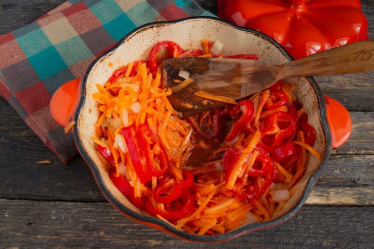 Simmering the vegetable sauce with tomato purée Tomato purée, salt, and sugar added to the vegetables in the skillet to create the sauce.