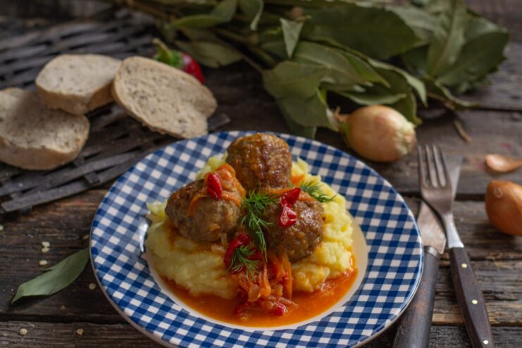 Serving the hearty Italian meatballs with creamy mashed potatoes The final dish: Italian meatballs in sauce served over mashed potatoes, garnished with fresh dill.