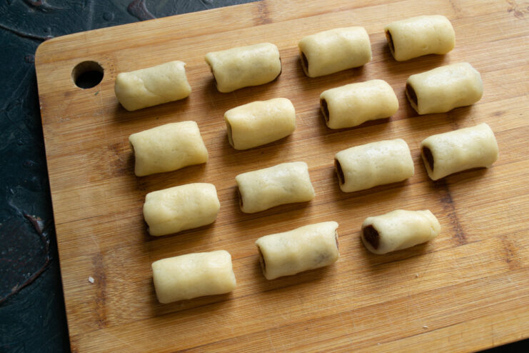 Cutting the dough logs into individual cookies The two-tone dough log being cut into 4 cm pieces to form the Nascondini cookies.