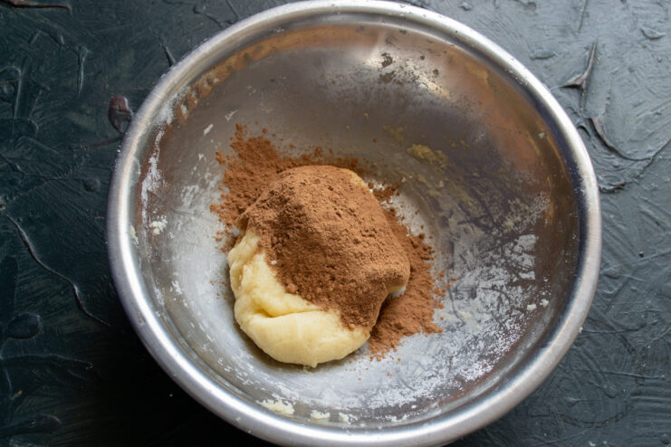 Adding cocoa powder to create the chocolate dough Unsweetened cocoa powder being added to a portion of the cookie dough.