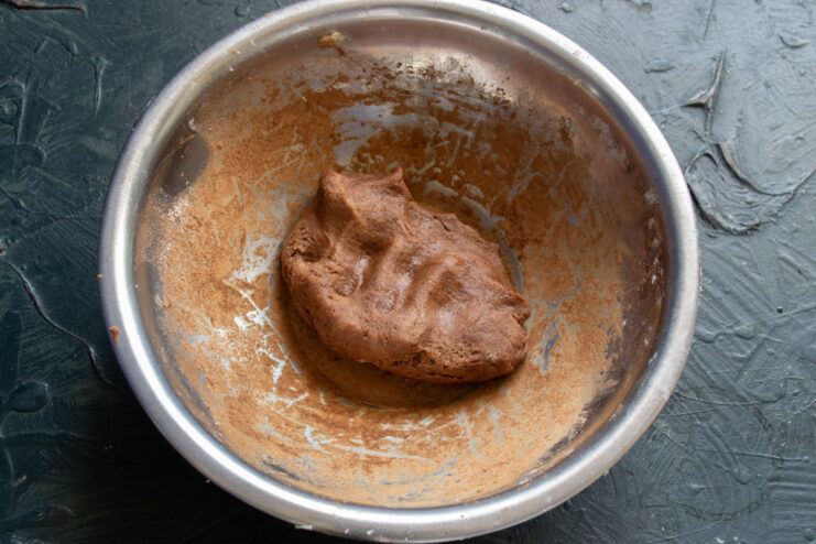Mixing melted chocolate into the cocoa dough Melted dark chocolate being mixed into the cocoa cookie dough.