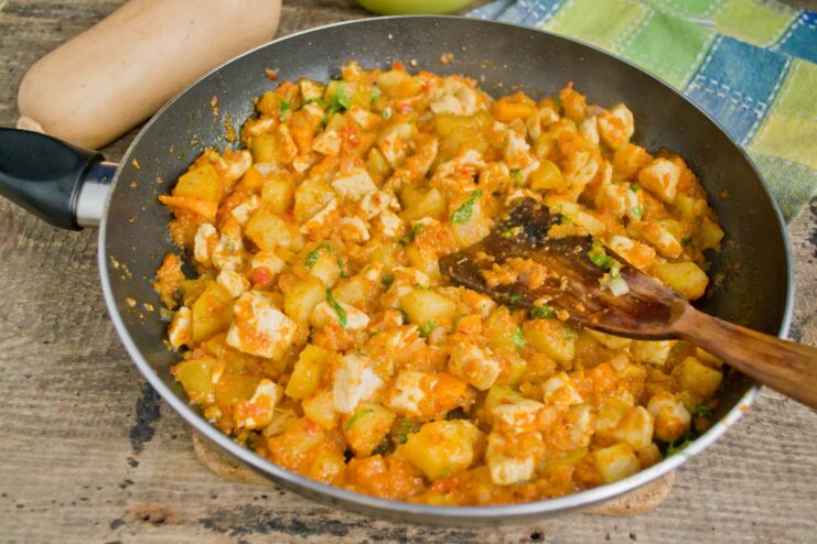 Finishing the stew with fresh herbs for a burst of freshness. Adding chopped fresh herbs to the finished stew in the skillet.