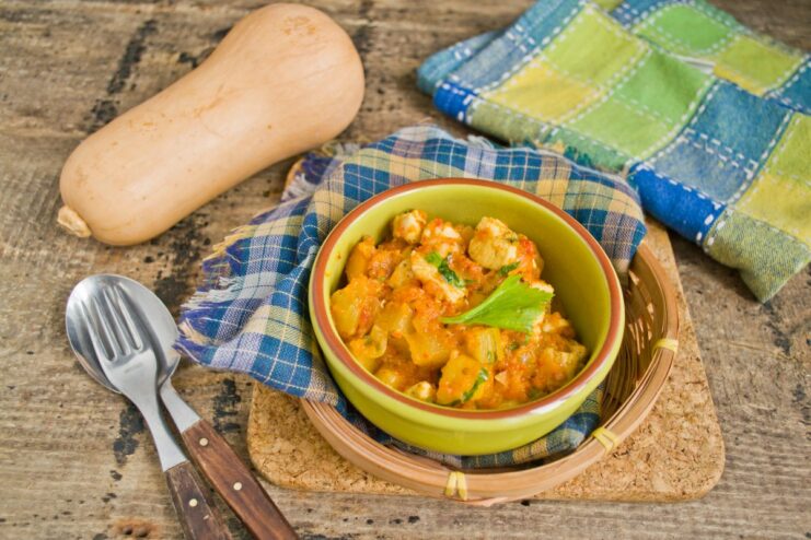 The perfect autumn stew is ready to be served and enjoyed. A close-up of the finished zucchini, pumpkin, and chicken stew in the skillet.