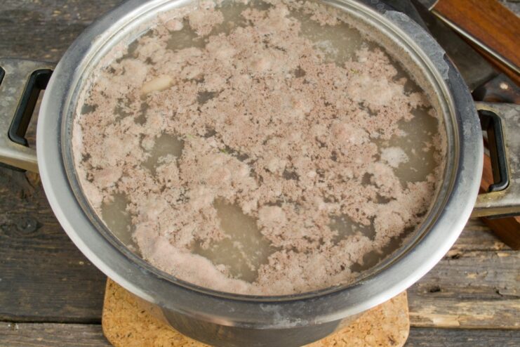 The first boil helps to start the cleaning process for the kidneys. Pork kidneys in a pot of boiling water for the first time.