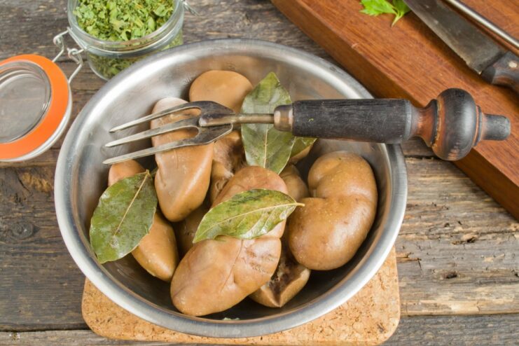 Perfectly cooked, tender, and odor-free pork kidneys ready to be used. A plate of sliced, fully cooked pork kidneys, ready to be used in a dish.