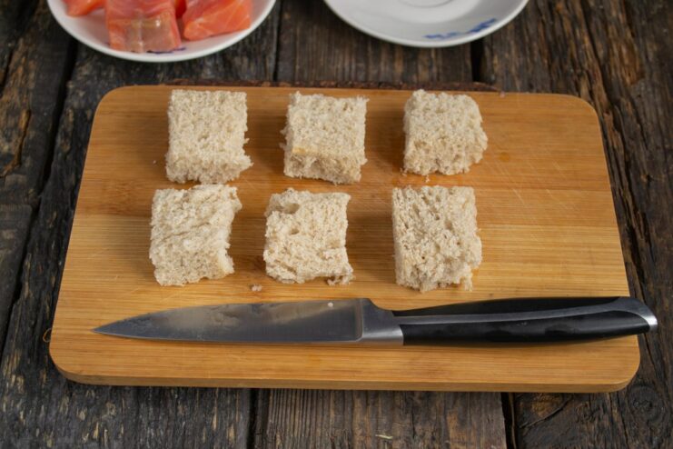 Preparing toasted bread cubes for canapés Cubes of white bread on a baking sheet, ready to be toasted in the oven.