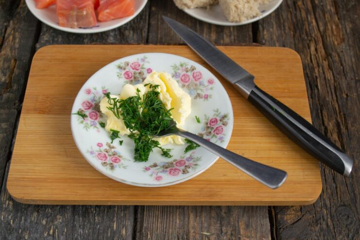 Making homemade dill butter for canapés Freshly chopped dill being mixed into a bowl of softened butter.