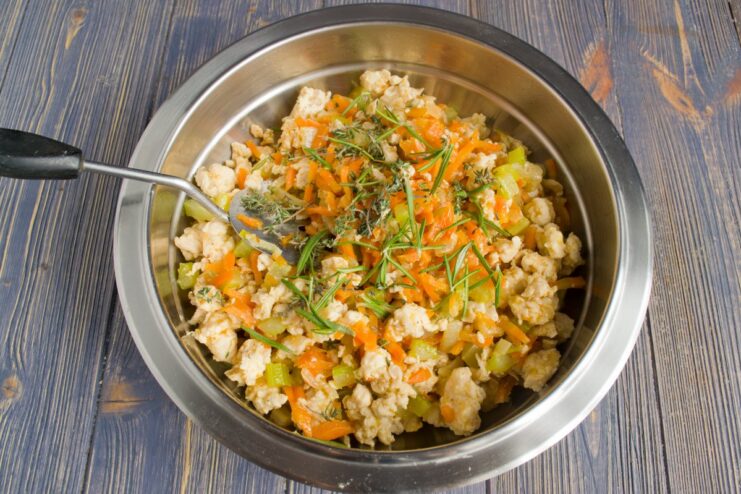 Sautéing Vegetables and Meat for a Flavorful Casserole Filling A mix of ground chicken, chopped onions, carrots, and celery being sautéed in a pan.