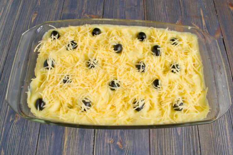 Sprinkling Grated Hard Cheese for a Golden, Crispy Top A generous amount of grated hard cheese being sprinkled over the casserole before baking.