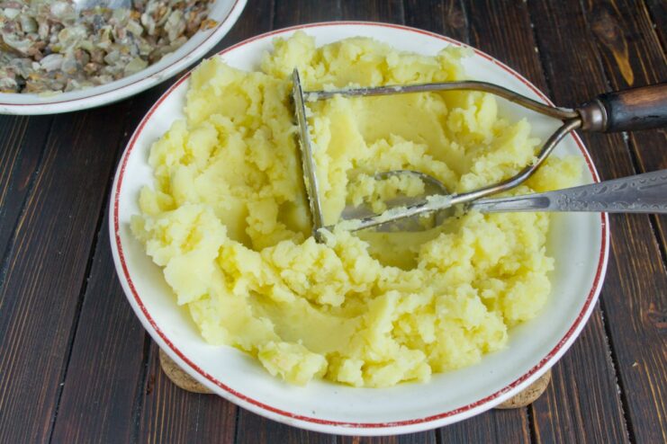 Making the Potato Base: Mashing Boiled Potatoes Freshly mashed potatoes in a bowl, ready for making the dough.