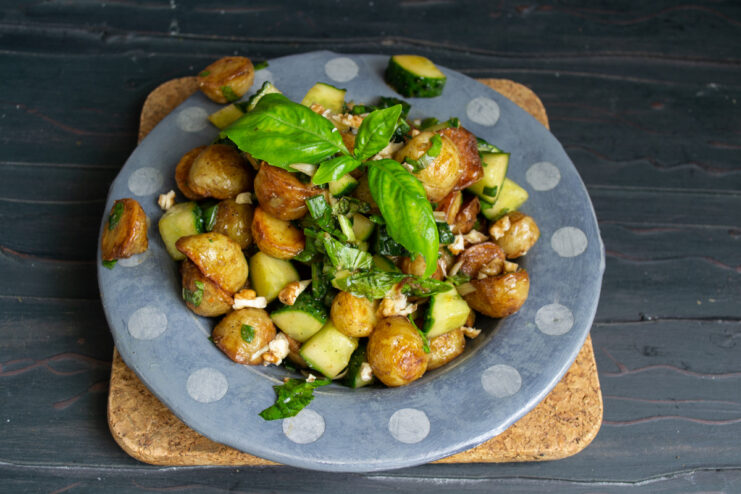 Serving the Potato Cucumber Salad Plating the finished potato salad with cucumbers, garnished with chopped walnuts.