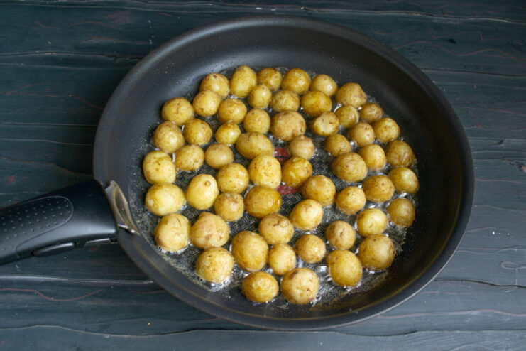 Pan-Frying Potatoes Until Golden Chopped potatoes being pan-fried in a skillet until they start to turn golden.