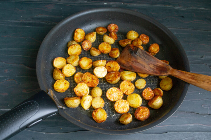 Perfectly Golden-Brown Fried Potatoes Golden-brown, crispy potatoes in a non-stick skillet, ready for the salad.