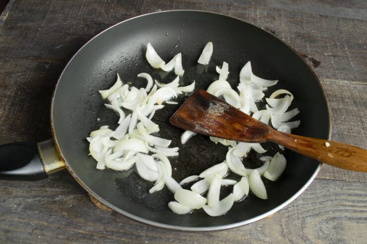 Step 2: Frying chopped onions in a pan until soft. Chopped onions being sautéed in a hot pan with oil.