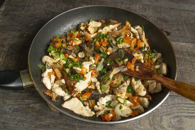 Step 6: Seasoning the dish and adding fresh basil. The chicken and vegetable mixture in the pan, seasoned and sprinkled with fresh basil.