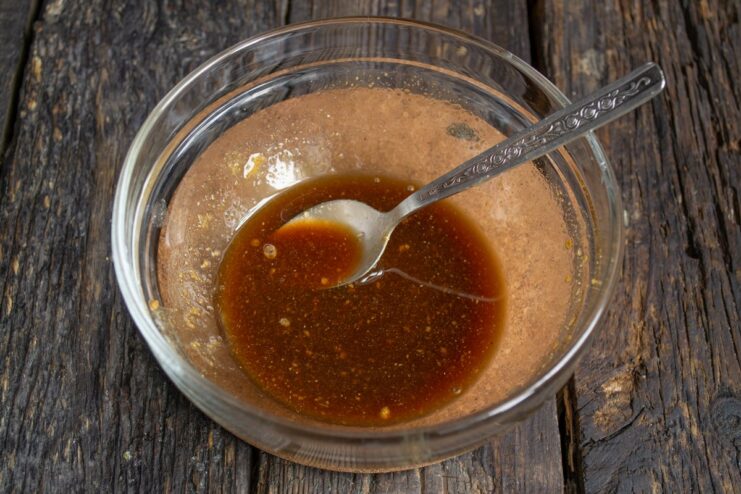 Pouring rice wine into the bowl with other teriyaki sauce ingredients.