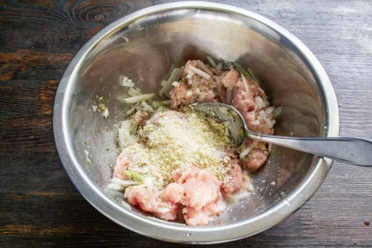 Using Breadcrumbs as a Binder Breadcrumbs being sprinkled into the bowl with the sausage meat mixture.