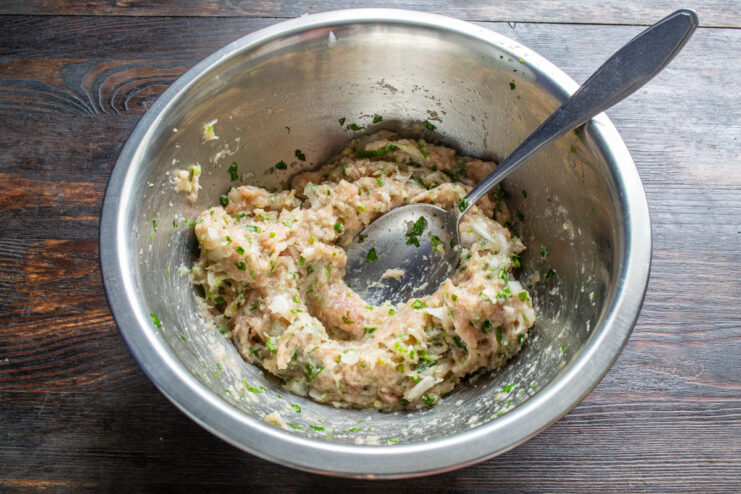Adding Fresh Herbs for Aroma Finely chopped fresh cilantro being added to the sausage mixture.