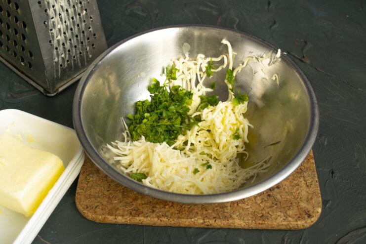 Step 3: Mixing grated butter, parmesan, and parsley for the filling A bowl with the filling for Kotlety de-volyay: grated butter, cheese, and herbs.