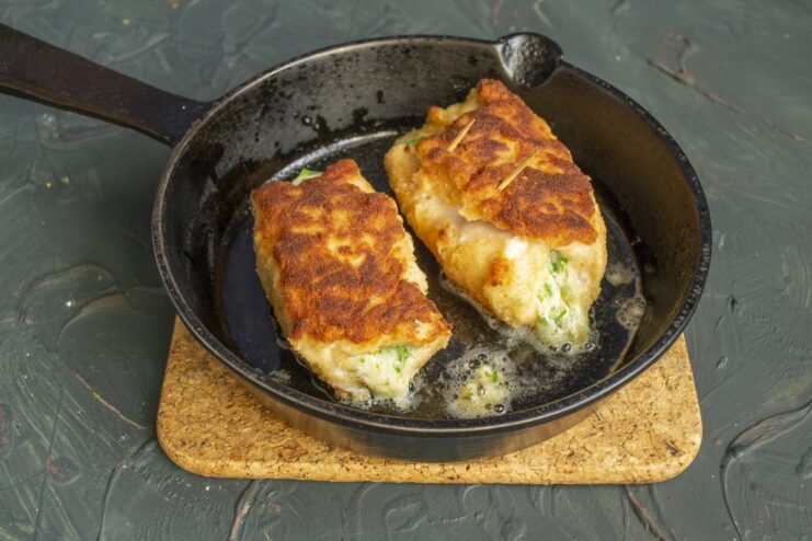 Step 7: Frying the cutlets until golden, then finishing in the oven Golden-brown chicken cutlets frying in a pan.