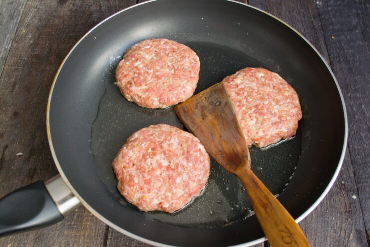 Several meat patties (kotlety) being pan-fried in a skillet.