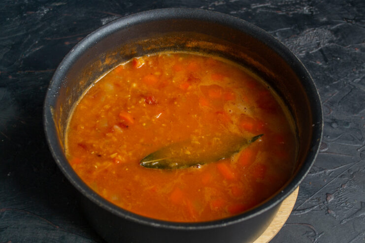 Tip: Add more hot water or broth if the soup becomes too thick. Adding hot water to the simmering lentil soup to adjust consistency.