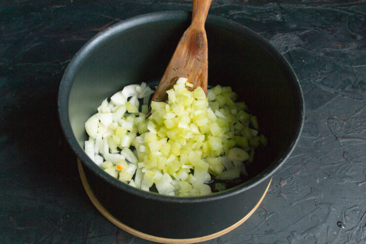 Adding diced celery to the pot with onions and garlic. Diced celery being added to the pot with sautéed onions and garlic.