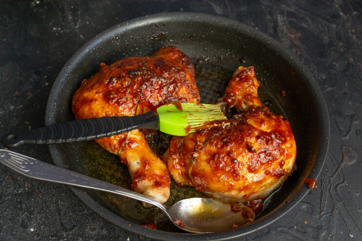 Basting the Chicken with Pan Juices for Extra Flavor and Moisture Basting the BBQ chicken with pan juices and a final layer of glaze.