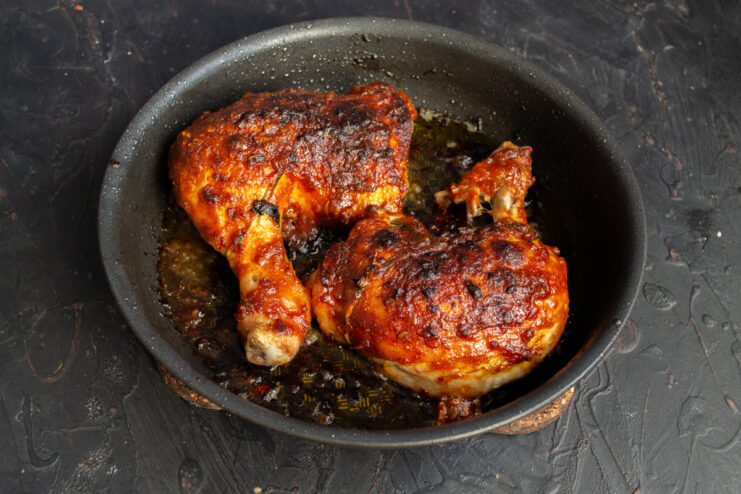 Serving the Perfectly Cooked Oven-Baked BBQ Chicken The finished oven-baked BBQ chicken served on a plate with a side of fresh salad.