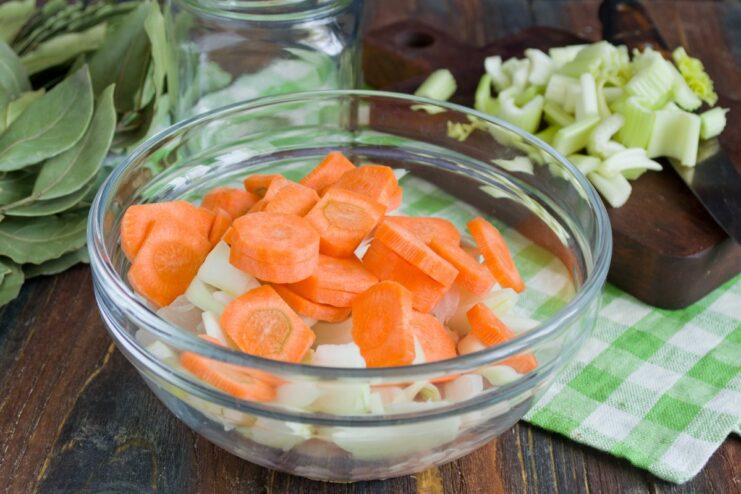 Mixing in Carrots for Flavor and Color Thick carrot slices added to the bowl with chicken and onions.