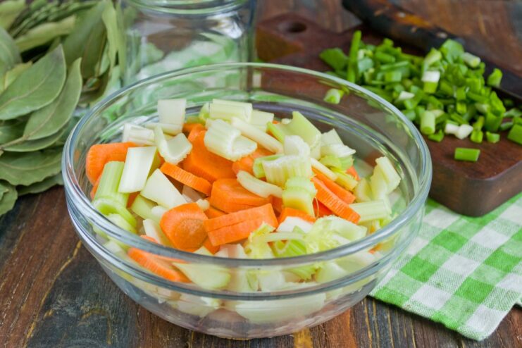 Adding Freshly Chopped Celery Chopped celery being added to the mixture of chicken and vegetables.