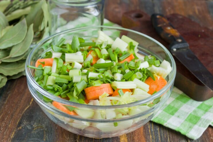 Sprinkling in Chopped Green Onions Chopped green onions are added to the bowl with other ingredients.