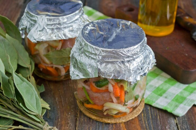 Placing Jars in a Cold Oven to Prevent Cracking Glass jars filled with chicken mixture, covered with foil, placed on an oven rack.