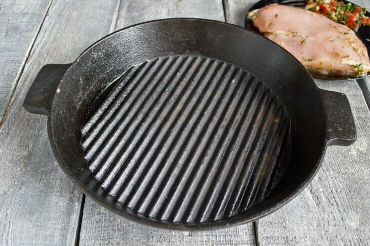 Preheating the grill pan is essential for a good sear. A cast-iron grill pan heating up on a stove.