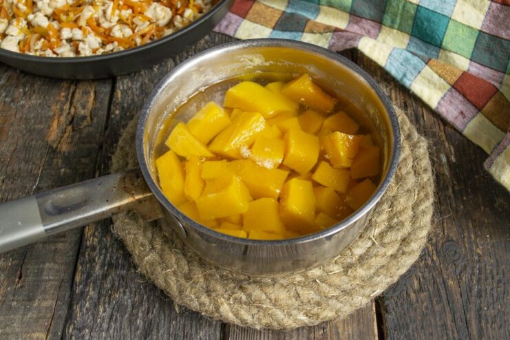 Boiling Diced Pumpkin Until Tender Cubes of bright orange pumpkin being boiled in a pot of water.
