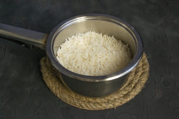 Cooking rice until tender, an essential component of the cabbage roll filling. Cooked white rice in a stainless steel saucepan.