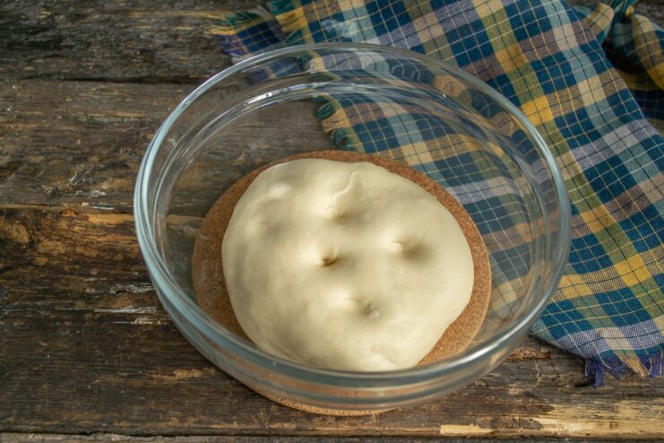 The finished dough for lazy pelmeni, ready to be chilled A smooth ball of dough resting on a floured surface before being refrigerated.