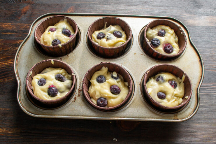 Step 7: Portioning the batter into muffin liners Muffin batter being scooped into paper liners in a muffin tin.