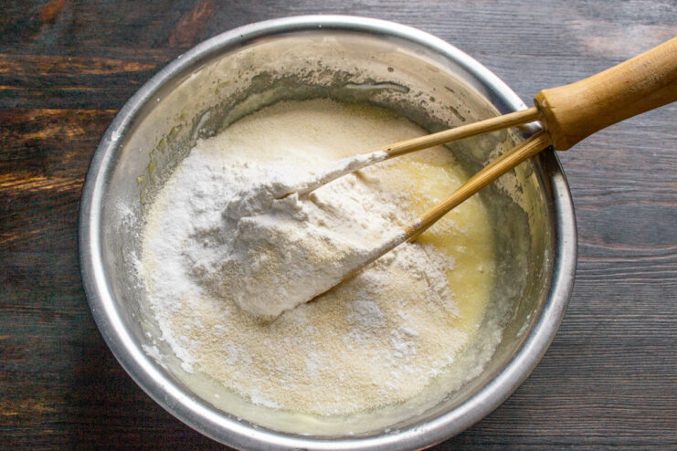 Pro Tip: Combine dry ingredients before adding to wet ingredients A bowl containing the dry ingredients for the muffins: flour, semolina, and baking powder.