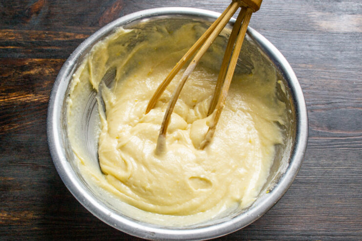 Step 4: Combining all ingredients into a smooth muffin batter A close-up of the finished muffin batter being mixed with a spatula in a bowl.